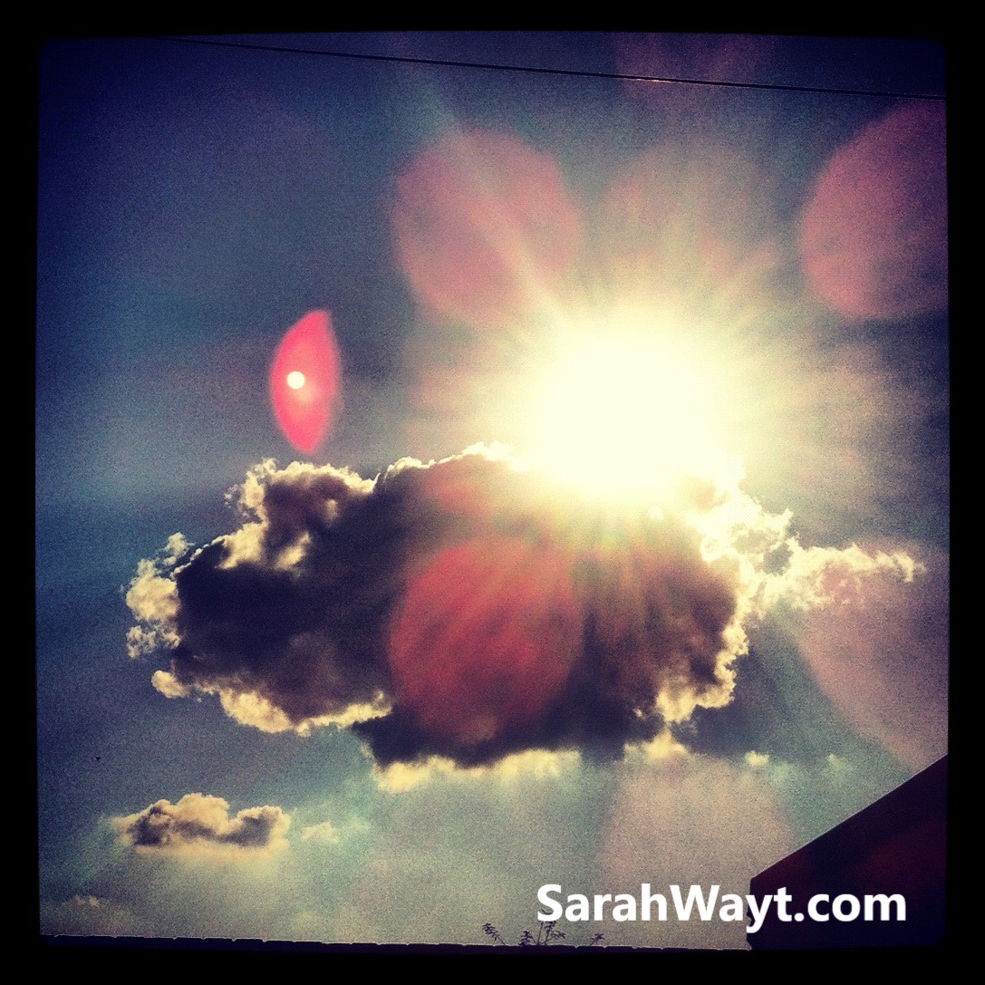 the beauty of a sunny day shining through a darkened cloud